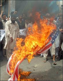 A US flag being burnt in protest.